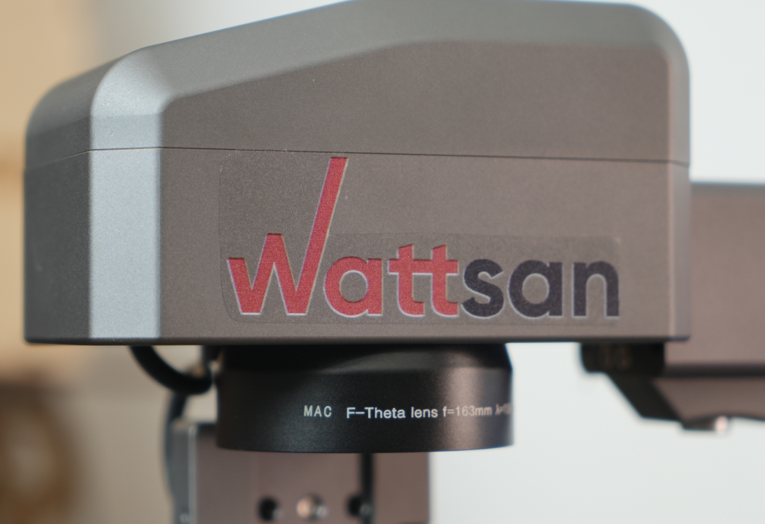 Детальное фото корпуса сканатора с логотипом Wattsan и установленным объективом для лазерной маркировки.