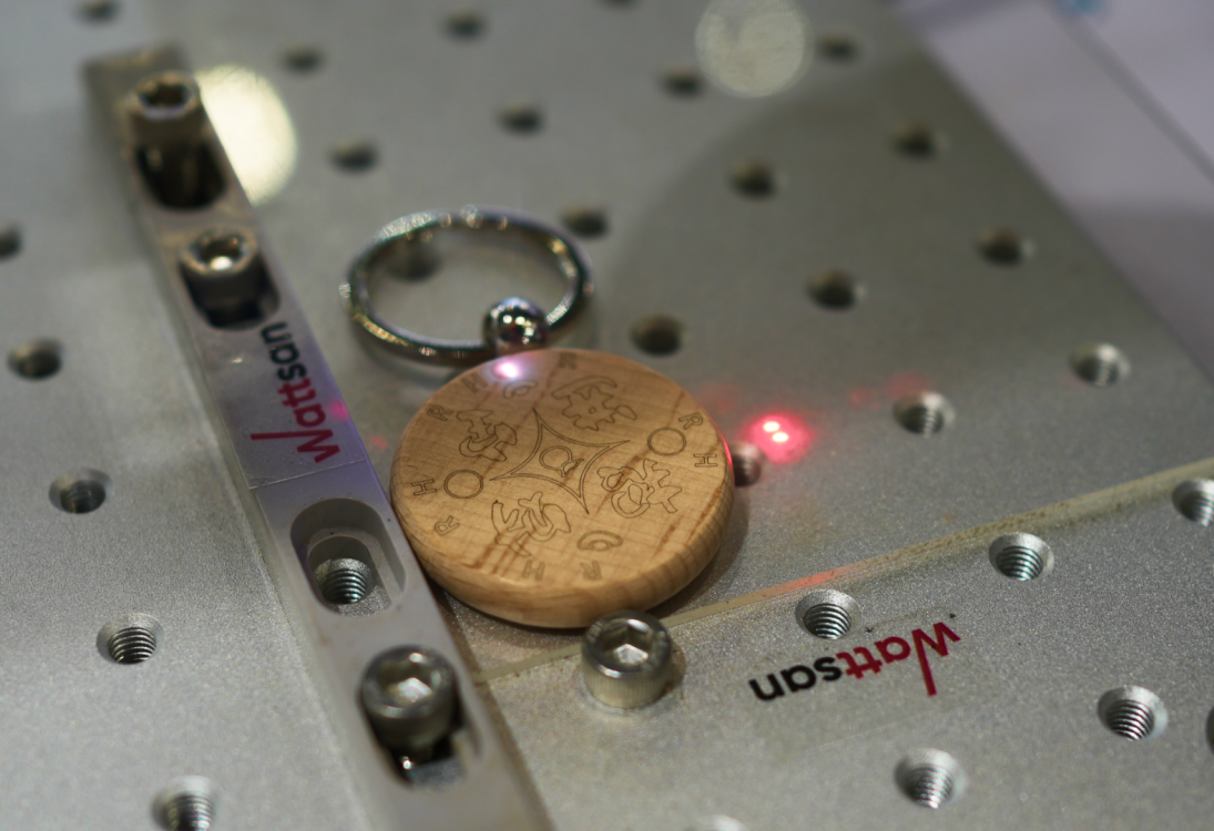 Деревянный круглый брелок с замысловатой гравировкой, прикреплённый к металлическому кольцу, красное свечение, "Wattsan" на планках