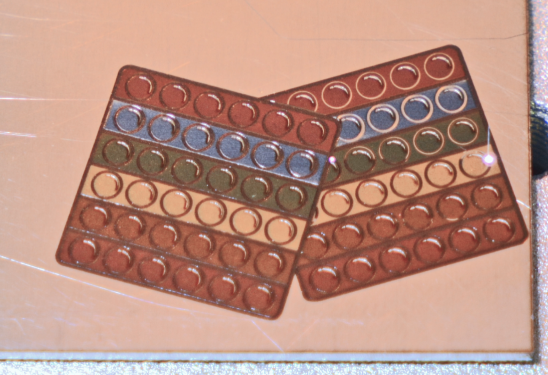 Два цветных поп-ита с рядами кругов в радужных оттенках на металлической поверхности